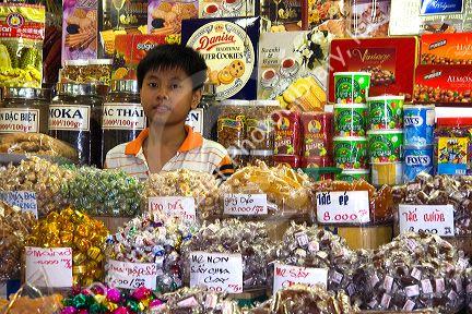 Young Vietnamese boy selling treats in the Ben Thanh Market located in Ho Chi Minh City, Vietnam.