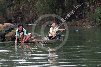 Vietnamese people transporting fishing nets by boat on the Perfume River at Hue, Vietnam.