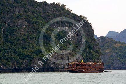 Scenic views of limestone isles and boats in Ha Long Bay, Vietnam.