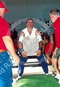 Man lifting a slab of rock in a weightlifting event at a Basque Festival in Boise Idaho.