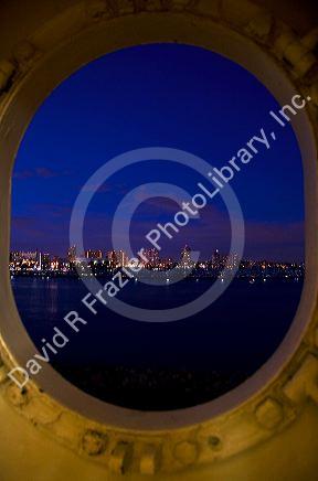 View of the city of Long Beach at night from a porthole on the Queen Mary museum and hotel ship at Long Beach, Califorina, USA.