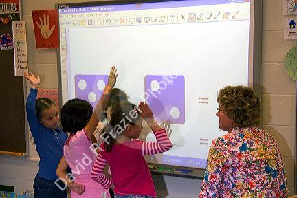 Kindergarten students use an interactive whiteboard in the classroom of a public school in Boise, Idaho, USA. MR