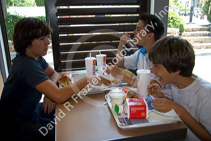 French teenage boys eat at a McDonalds fast food restaurant in Southern France.
