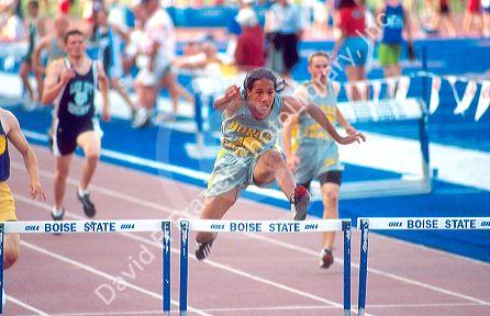 Male high school student competeing in a hurdles track event. Boise, Idaho.
