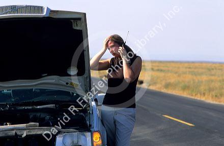 Stranded woman using a cell phone to call for help.