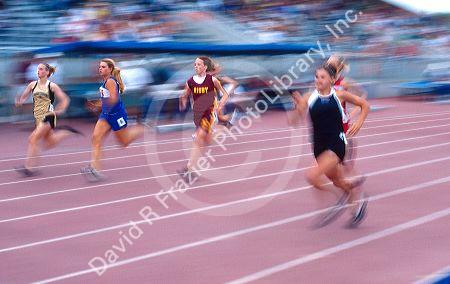 High school girls running in a track event.