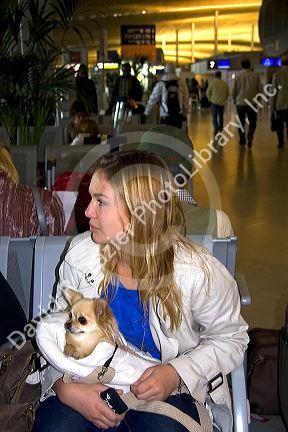 Woman traveling with a small dog in the Paris-Charles de Gaulle Airport, Paris, France.