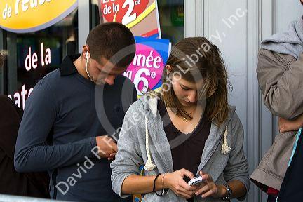 French female student viewing images on a digital camera in the Latin Quarter of Paris, France.