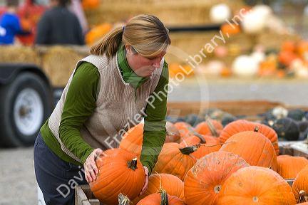 Woman shopping for pumpkins at a farmers market in Fruitland, Idaho. MR