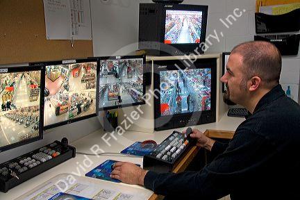 Security officer watching video monitors in the control room of a supermarket in, Idaho, USA.
