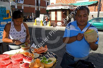 Street vendor carving and selling melon in the city of Puebla, Puebla, Mexico.