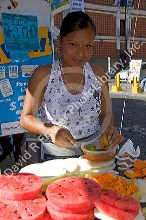 Street vendor carving and selling melon in the city of Puebla, Puebla, Mexico.
