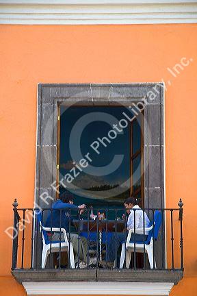 People dine on a restaurant balcony in the city of Puebla, Puebla, Mexico.