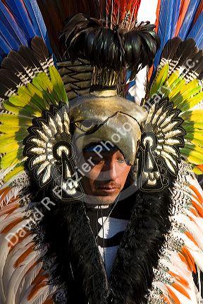 Native Aztec people dance wearing tradional costume in the Zocalo of Mexico City, Mexico.