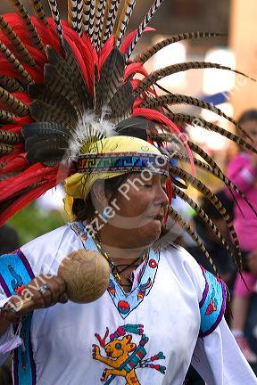Native Aztec people dance wearing tradional costume in the Zocalo of Mexico City, Mexico.