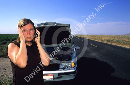 Stranded woman using a cell phone to call for help.