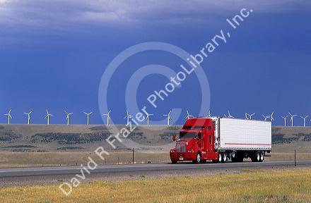 A truck traveling on the highway with a row of windmills in the background near Arlington, Wyoming.
