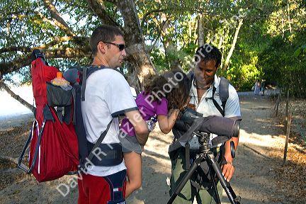Young girl looking through a telescope at wildlife in the Manuel Antonio National Park in Puntarenas province, Costa Rica.