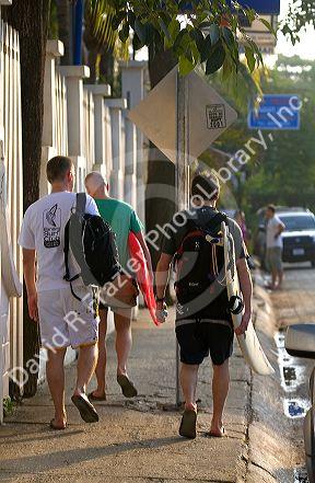 Tourists carry surf boards in the town of Tamarindo on the Northern Pacific Coast of Costa Rica.