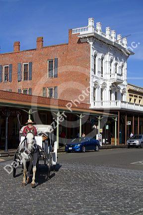 Tourists ride in a horse drawn carriage at Old Sacramento State Historic Park in Sacramento, Califorina, USA.