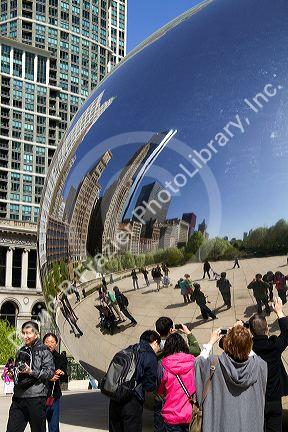 Visitors look at their reflection in the Cloud Gate public sculpture located at the AT&T Plaza in Millennium Park, Chicago, Illinois.