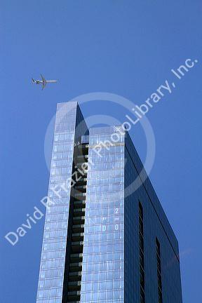 Airplane flying over a tall building in Chicago, Illinois, USA.
