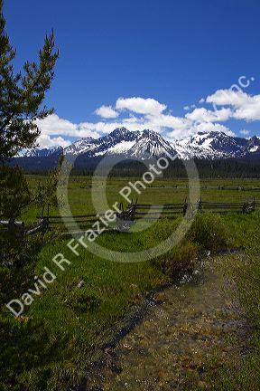 Split rail fencing and a fresh water creek running through a meadow near Stanley, Idaho, USA.