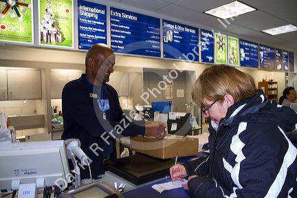 Female customer and male african american postal worker in Boise, Idaho, USA.
