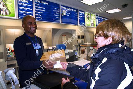 Female customer and male african american postal worker in Boise, Idaho, USA.