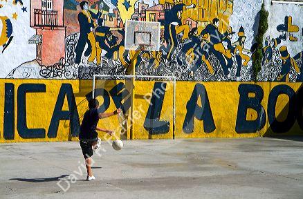 Argentine boy playing soccer in the La Boca barrio of Buenos Aires, Argentina.