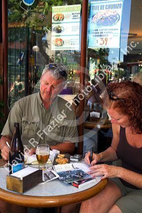 Tourists write postcards at an outdoor cafe in Buenos Aires, Argentina.