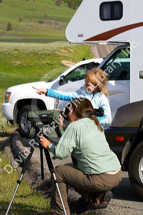Mother and daughter viewing wildlife in Yellowstone National Park, USA. MR