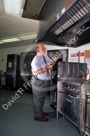 A health inspector at a retirement home kitchen. (MR)