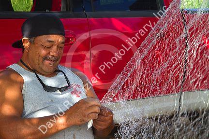 Native hawaiian fisherman mending a net on the island of Kauai, Hawaii, USA. MR