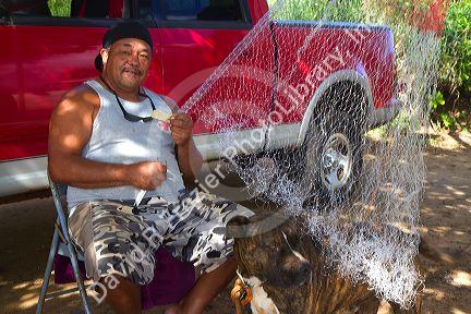 Native hawaiian fisherman mending a net on the island of Kauai, Hawaii, USA. MR