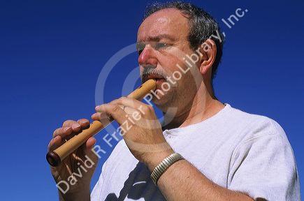 A man plays a soprano recorder.