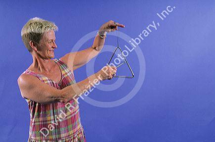 A woman playing a triangle.