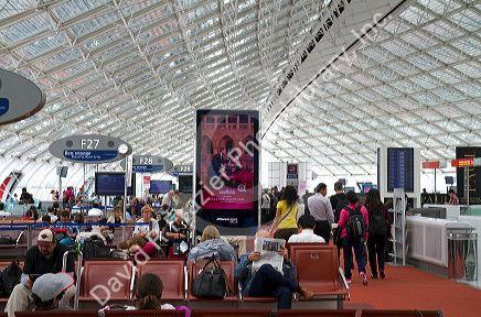 Travelers in a waiting room at Charles de Gaulle Airport, Paris, France.