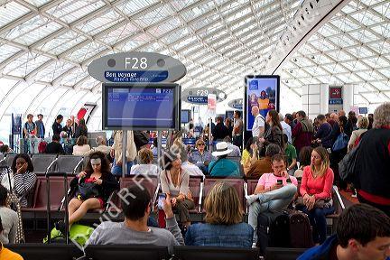 Travelers in a waiting room at Charles de Gaulle Airport, Paris, France.