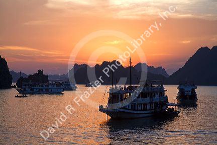 Tour boats at sunset in Ha Long Bay, Vietnam.