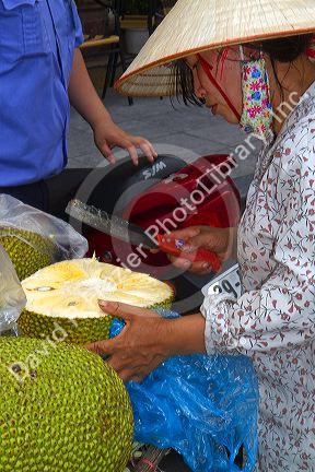 Vietnamese street vendor selling durian fruit in Hanoi, Vietnam.