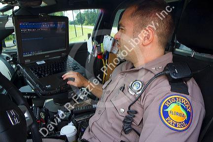 Florida state trooper using computer in patrol car.