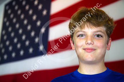 Ten year old american boy standing in front of an american flag in Charleston, South Carolina, USA. MR
