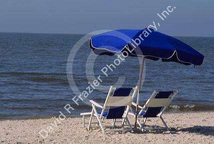 Gulf coast beach scene with chair and umbrella.