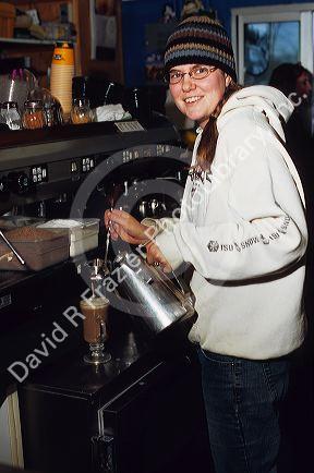 A female employee making coffee drinks at a coffee shop in Boise, Idaho.