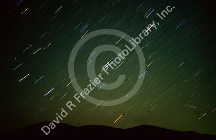 Medeorite shower and star trails.  Different gases create a variety of colors in stars.  Meteorite at right passes through the star trails created by the earth's rotation in this time exposure. 