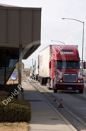 Long haul trucks line up a weigh station.