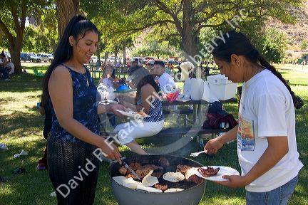 Hispanic women having barbecue at a picnic in the park. Sandy Point near Boise, Idaho.