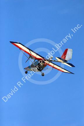 An ultralight aircraft flying in the sky.