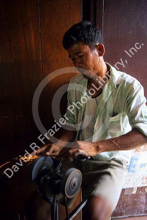 A man sharpening scissors in the Philippines.